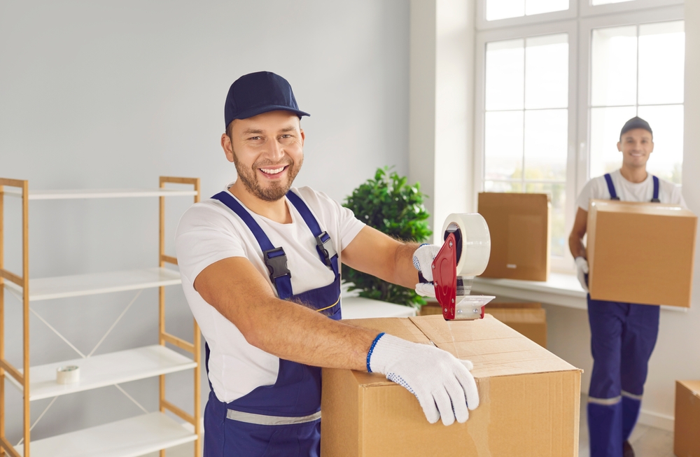 Portrait,of,a,mover,sealing,a,cardboard,box,with,duct